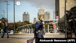 Жена носи маска за лице шетајќи во центарот на Москва, 28 септември 2021 година