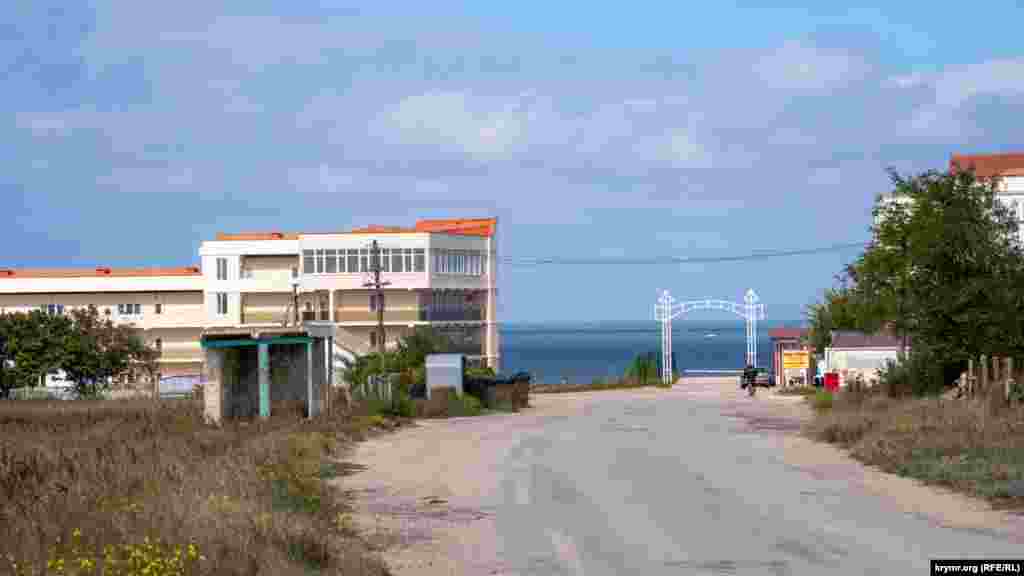 Улица Нововосточная ведет к главному входу с аркой на пляжи. Слева &ndash; автобусная остановка. В Феодосию рейсовые автобусы оттуда отправляются три раза в день и один раз в неделю, во вторник, в райцентр Ленино