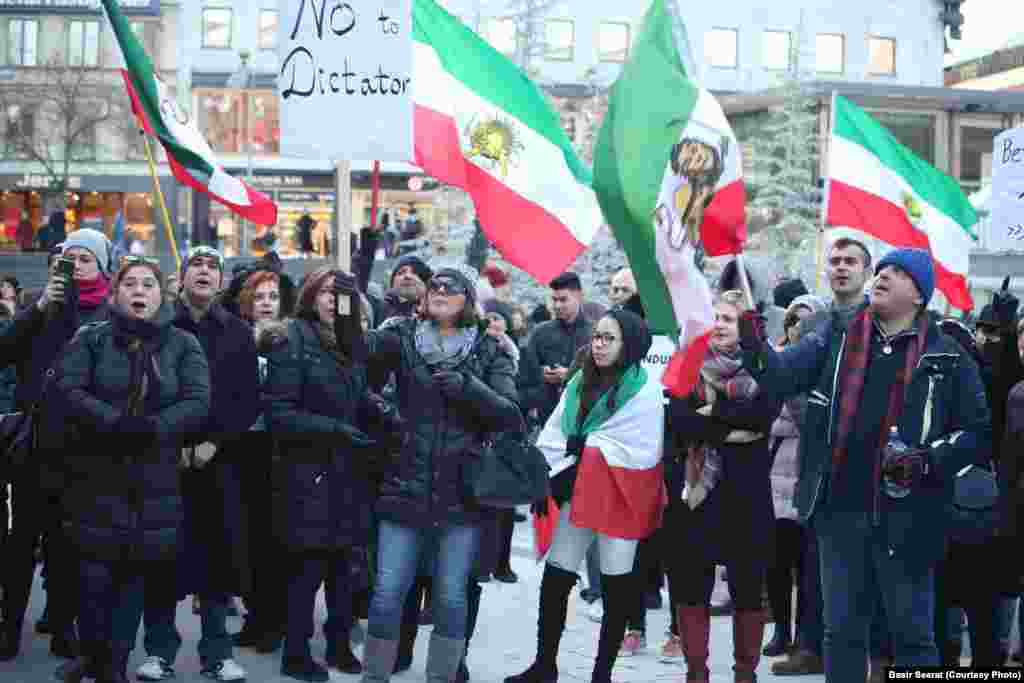 Флаги времен правления шаха в Иране в руках у протестующих в Стокгольме.&nbsp;