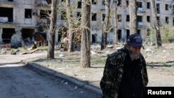 Илустрација - Жител на Авдивијка пред уништена станбена зграда