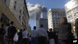 Pešaci u donjem Menhetnu gledaju dim koji izlazi iz kula Svetskog trgovinskog nakon terorističkog napada, Njujork, 11. septembar 2001.