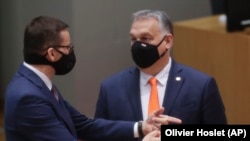 Premierul polonez Mateusz Morawiecki (stânga) și premierul ungar, Viktor Orban (dreapta), într-o discuție la summitul UE de la Bruxelles, din 10 decembrie 2020