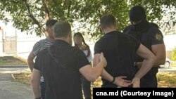 Imagine distribuită de CNA de la reținerea a 15 persoane într-un dosar de finanțare ilegală a partidelor și corupere electorală.