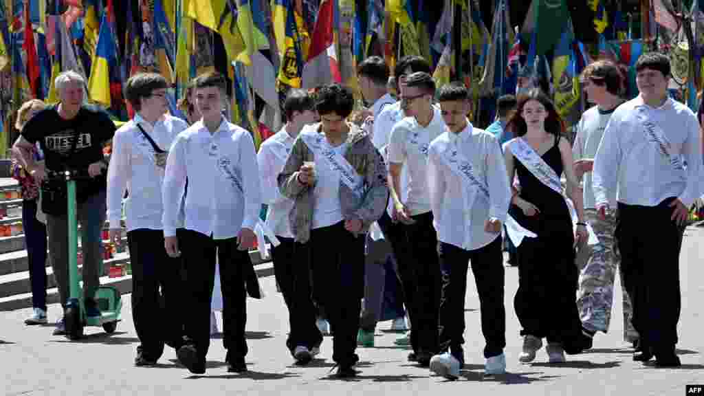 Az orosz támadások veszélye folyamatosan ott lebeg az iskolák felett Ukrajna-szerte. A Save the Children szerint a légi riasztások miatt a gyerekek az elmúlt tanévben átlagosan minden ötödik iskolai óráról lemaradtak. Az ENSZ adatai pedig arról árulkodnak, hogy a 2022 februárjában kezdődött háború első három évében több mint 1600 iskola rongálódott vagy semmisült meg. A képen ukrán diákok sétálnak a Függetlenség terén az egyik kijevi iskolában tartott ballagás után 2025. május 30-án