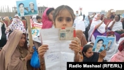 FILE: Thousands of women, children, and men held up photos, placards, or the national ID cards of their missing family members in Peshawar, Pakistan in April 2018.