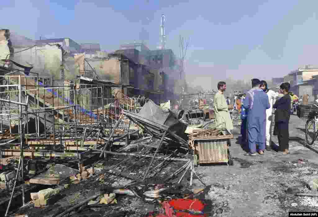 Afghans inspect damaged shops in the northern city of Kunduz after clashes between Taliban fighters and Afghan security forces on August 8. With some 375,000 inhabitants, Kunduz would be the most significant city to fall since the Taliban launched an all-out offensive in May as U.S.-led forces began the final stages of their withdrawal.