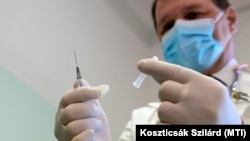 Szlávik János infektológus főorvos egy Pfizer és a BioNTech által kifejlesztett koronavírus elleni oltóanyaggal a Dél-pesti Centrumkórházban 2020. december 26-án.