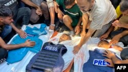 Oamenii jelesc trupurile jurnaliștilor palestinieni Moaz Abu Taha (stânga), fotoreporterului Hussam al-Masri, contractant Reuters (centru), și fotoreporterului Al-Jazeera Mohamed Salama (dreapta), care au fost uciși într-un atac israelian.