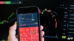 Ova fotografija snimljena 7. aprila 2025. prikazuje grafikon dionica i indeks prikazan na pametnom telefonu 