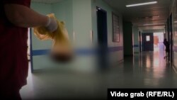 Një infermiere në Klinikën e Gjinekologjisë bart një qese me placentë.