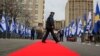 Një zyrtar policor kalon përmes tepihut të kuq, të shtruar pranë Ministrisë së Jashtme dhe Diasporës, ku u mbajt ceremonia virtuale për vendosjen e marrëdhënieve diplomatike me Izraelin. Prishtinë, 1 shkurt, 2021.
