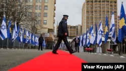 Një zyrtar policor kalon përmes tepihut të kuq, të shtruar pranë Ministrisë së Jashtme dhe Diasporës, ku u mbajt ceremonia virtuale për vendosjen e marrëdhënieve diplomatike me Izraelin. Prishtinë, 1 shkurt, 2021.
