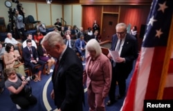 Глава сенатского меньшинства Чак Шумер и его коллеги покидают пресс-конференцию, на которой они представили свою позицию накануне шатдауна