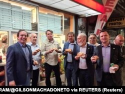 Brazilski predsjednik Jair Bolsonaro sa članovima svog kabineta jede pizzu na ulici u New Yorku u nedelju 19. septembra.