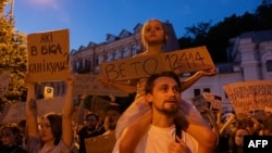Tată și fiică la protestul de joi de la Kiev împotriva slăbirii structurilor anticorupție.
