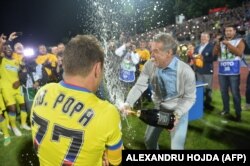 Gigi Becali, a Steaua Bukarest tulajdonosa (jobbra) pezsgőt locsol játékosaira a CSMS IASI és a Steaua Bukarest közötti labdarúgó-mérkőzés végén a romániai Jászvásáron 2015. május 28-án