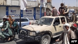 Victorious Taliban fighters drive an Afghan National Army vehicle through the streets of Laghman Province.
