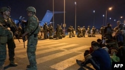 Ushtarët francezë bëjnë roje derisa shtetasit francezë dhe afganë presin të hipin në një aeroplan transporti ushtarak në aeroportin e Kabulit më 17 gusht 2021.