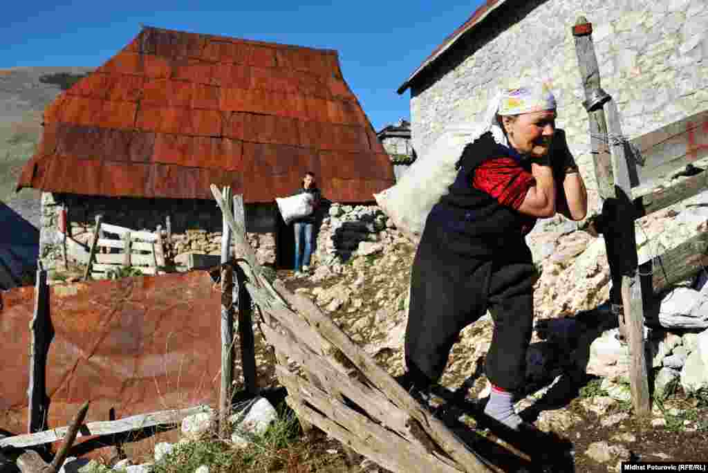 Sedamdesetsedmogodišnja Hatidža Čomor (1D) nosi vreću sa namirnicama koje će ponijeti sa sobom u niže krajeve gdje će biti tokom zime. Foto: Midhat Poturović