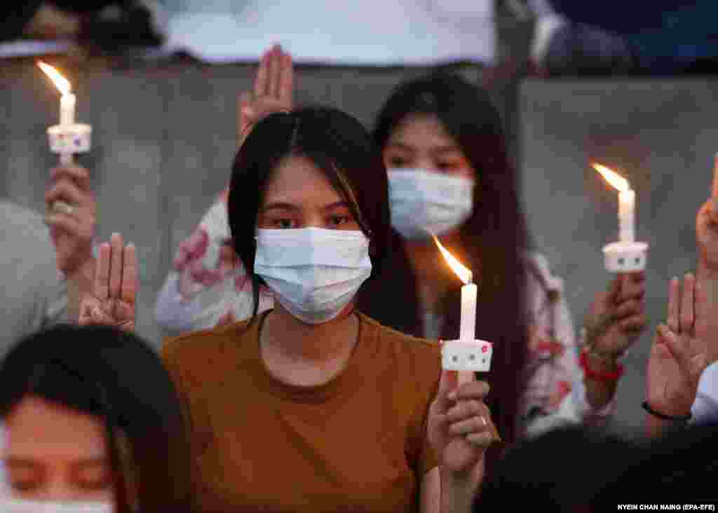 Demonstranti pokazuju tri prsta i drže svijeće tokom spomena umrloj Myi Thwe Thwe Khaing, ispred američke ambasade u Jangonu, 20. februar.