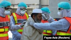 پيښور کې روغتياپالان د يو کس تبه ګورئ.