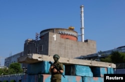 Российский военнослужащий стоит на страже на блокпосту возле Запорожской АЭС перед прибытием миссии экспертов МАГАТЭ, 15 июня 2023 года