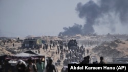 Палестинци носят чували с брашно, разтоварени от конвой с хуманитарна помощ в покрайнините на Бейт Лахия, северната част на ивицата Газа