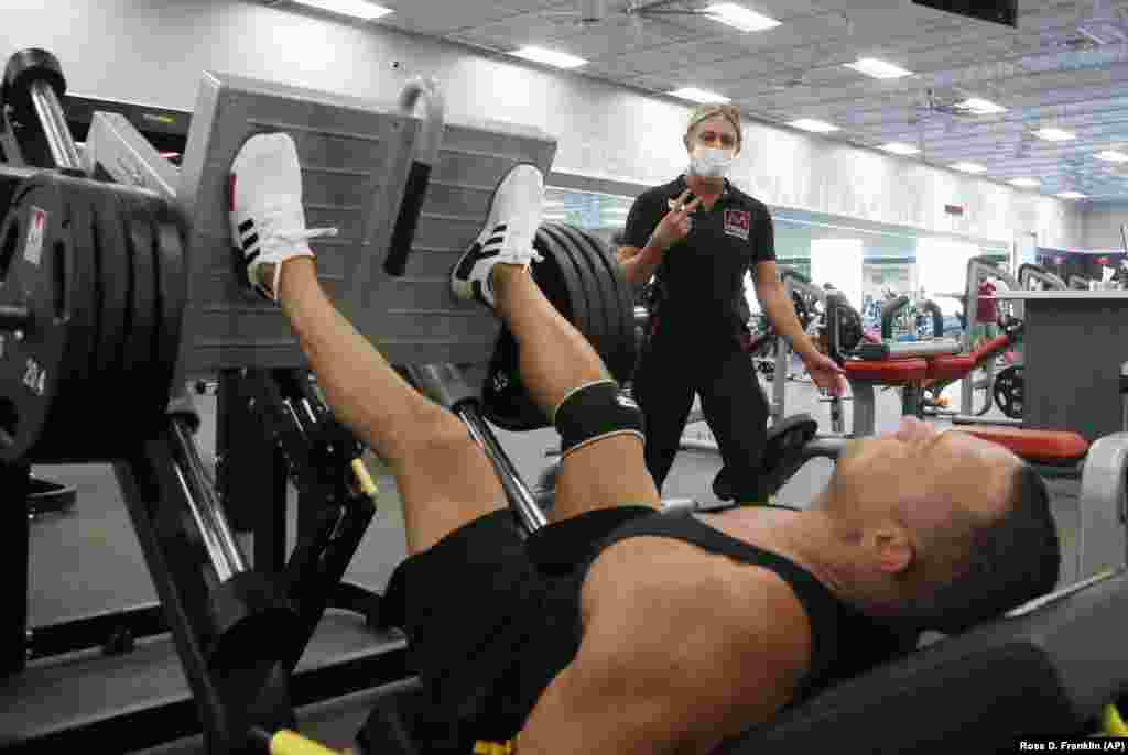 Тренер у фітнесклубі Mountainside Fitness працює з клієнтом. Центр залишається відкритим навіть після того, як губернатор штату Арізони Даг Дучі розпорядився закрити всі спортивні зали через сплеск кількості випадків коронавірусу в Аризоні. Кілька фітнесклубів ігнорували 30-денне розпорядження Дучі про закриття спортивних залів, барів, аквапарків