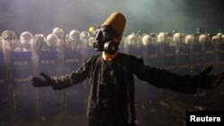 Demonstrant nosi dervišku odjeću i gas masku, gestikulira pored policije tokom protesta na dan kada je gradonačelnik Istanbula Ekrem Imamoglu zatvoren u sklopu istrage o korupciji, Istanbul, Turska, 23. mart 2025.