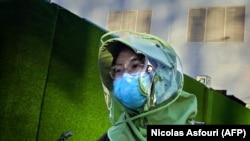 Žena sa zaštitnom opremom u Pekingu, april 2020. 