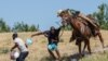 Na ovoj fotografiji, agent američke Pogranične službe na konju pokušava spriječiti migranta iz Haitija da uđe u kamp na obali Rio Grande u blizini Međunarodnog mosta Acuna Del Rio u Del Riou (19. septembra 2021.)