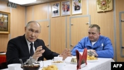 Vladimir Putin la o întâlnire cu marinarii pe submarinul nuclear Arkhangelsk, în timpul vizitei sale la Murmansk, într-o fotografie distribuită de agenția rusă de stat Sputnik, 27 martie 2025