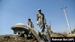 Afganistanski dječaci sakupljaju ostatke olupine nakon napada u Kabulu u kojem je ubijen hrvatski vojnik, 24. srpanj 2019.