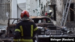 Пожарникари работат на местото на оштетените згради за време на руските напади со дронови и ракети во Лвив на 12 јули 2025 година.
