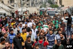 Trupurile jurnaliștilor uciși în Gaza în noaptea de duminică spre luni, purtate de palestinieni spre cimitir, la 11 august 2025.