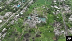 O școală în ruine, case deteriorate dar și a cratere provocate de exploziile obuzelor și rachetelor, într-o suburbie a orașului Donețk, Ucraina, 26 mai