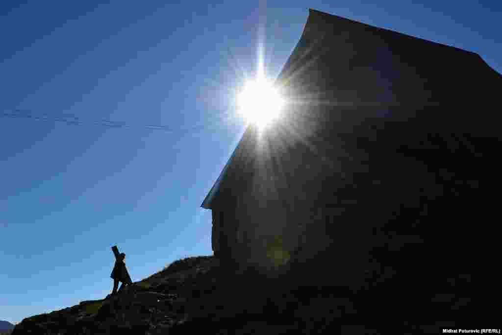Silueta čovjeka i kuće tokom dnevnog sunca u selu Lukomir, gdje se stanovnici spremaju da napuste selo prije zime. Foto: Midhat Poturović