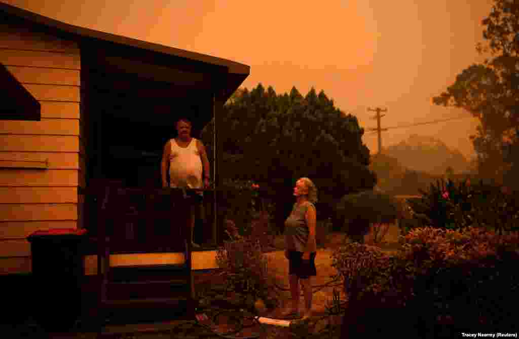 Nenci i Brajan Alen koriste baštenska creva da nakvase kuću i vrt oko nje u Nouri