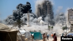 Palestinezët duke ikur pas një ndërtesë goditet nga një sulm ajror izraelit në Qytetin e Gazës më 5 shtator 2025. 