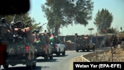 Afghan security officials patrol the highway connecting Kandahar to Helmand during a large Taliban attack on Helmand's capital Lashkar Gah.