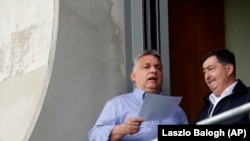 Orbán Viktor miniszterelnök Mészáros Lőrinccel beszélget a felcsúti stadionban 2019-ben