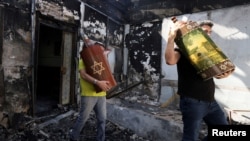 Мъже изнасят свитъци на Тората от опожарена синагога в град Лод, Израел. 12 май 2021 г.