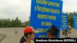 Девочки на акции протеста против изъятия земель с формулировкой "под государственные нужды" держат плакат с цитатой из Конституции Казахстана. Астана, 28 июня 2014 года. Иллюстративное фото. 