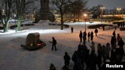 Oamenii se adună la monumentul dedicat victimelor represiunilor politice, Monumentul Piatra Solovețki, pentru a comemora moartea liderului opoziției ruse Alexei Navalnî, în Sankt Petersburg, Rusia, 16 februarie 2024.