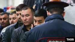 Un polițist verifică documente de identitate la un centru comercial din Novosibirsk, în octombrie 2024.