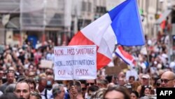 Снимка от протестите в Париж на 31 юли. На плаката пише "Не на здравния пропуск. Не на дискриминацията. Да на мира."