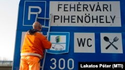 Elektromosautó-töltő állomást előjelző táblát helyeznek ki a fehérvári pihenő előtt 2016. december 3-án