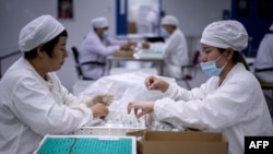 Veszettség elleni oltásokat pakolnak a koronavírus elleni oltás fejlesztésében is közreműködő Yisheng Biopharma dolgozói 2020. június 9-én.