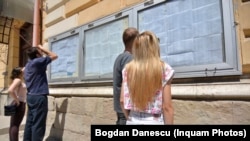 Elevi căutându-se pe listele cu notele de la examen