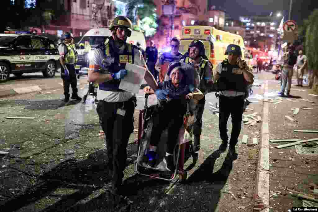 Israeli rescue workers evacuate a woman wounded in an Iranian missile strike on Ramat Gan, just east of Tel Aviv, on June 13.